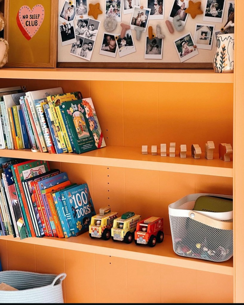 Bright and playful kids' room featuring bold orange built-in storage, colorful decor, and a cozy reading nook, inspired by Zoe Sugg's home aesthetic.