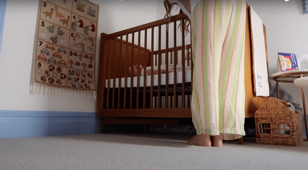Noviee's elegant brown wooden bed from West Elm UK, featuring a sleek modern design with warm wood tones that complement the cozy nursery aesthetic.