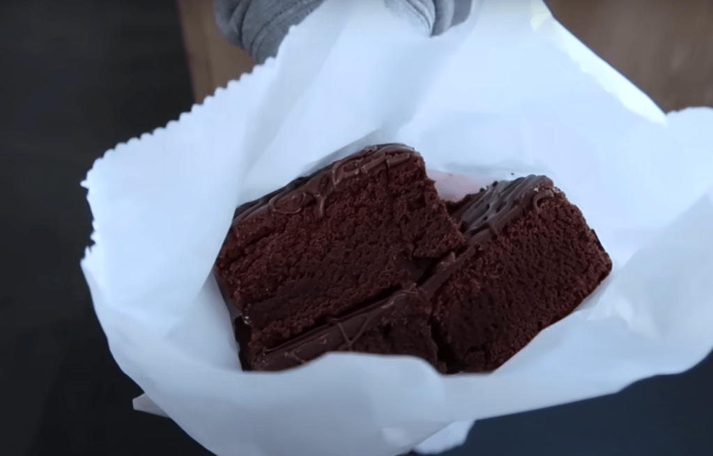 A stack of thick chocolate squares in a white bakery bag.