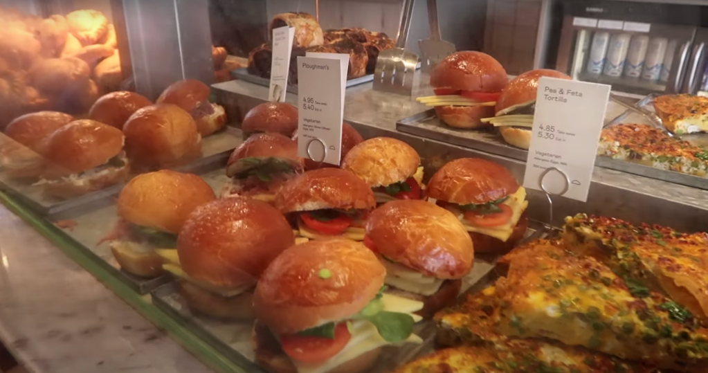 A close-up of bakery sandwiches, quiches, and Cornish pasties, showcasing a variety of fresh savory options at Coffee & Pastries.