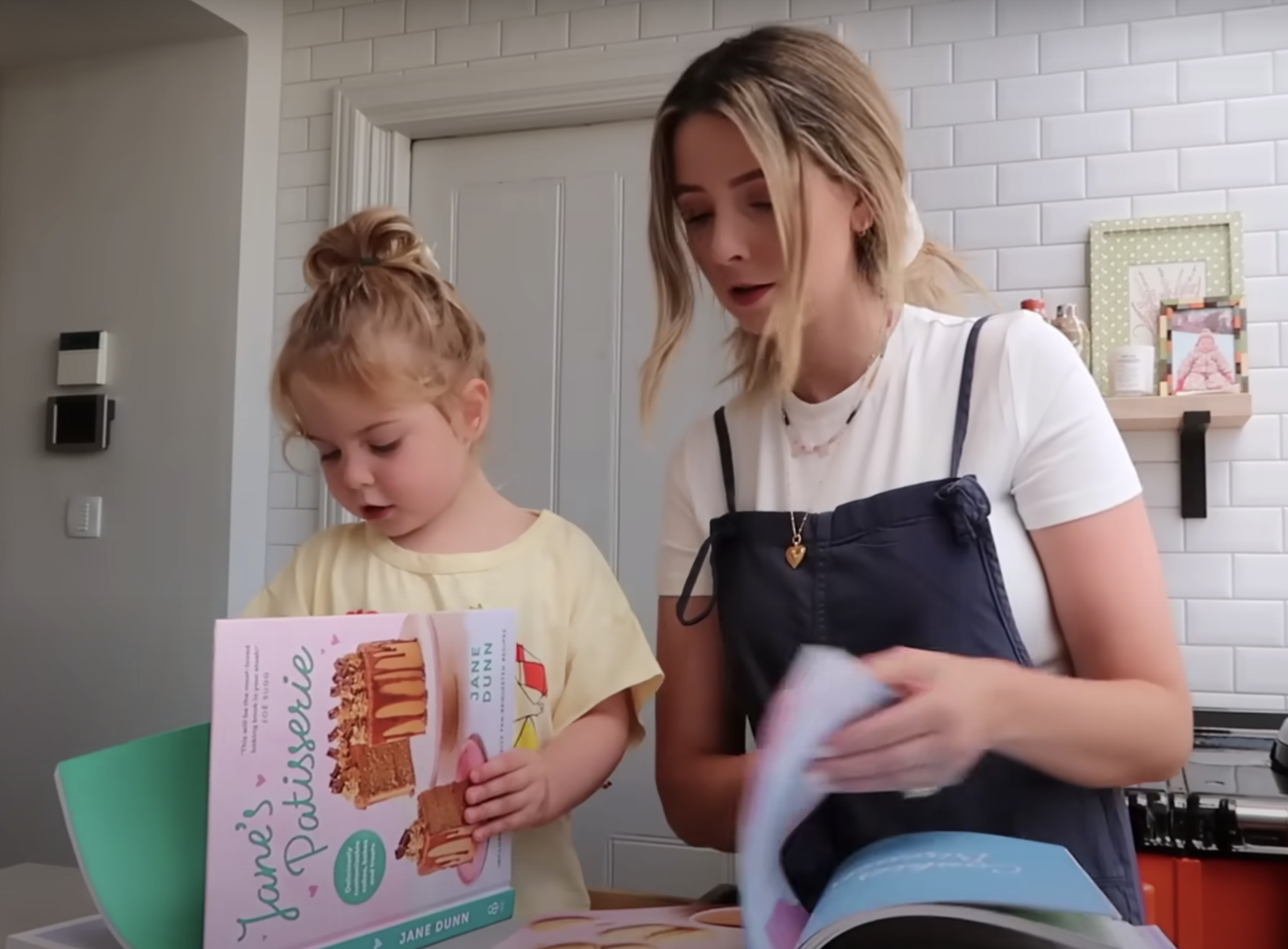 Zoe and Ottilie flipping through Jane’s Patisserie cookbook.
