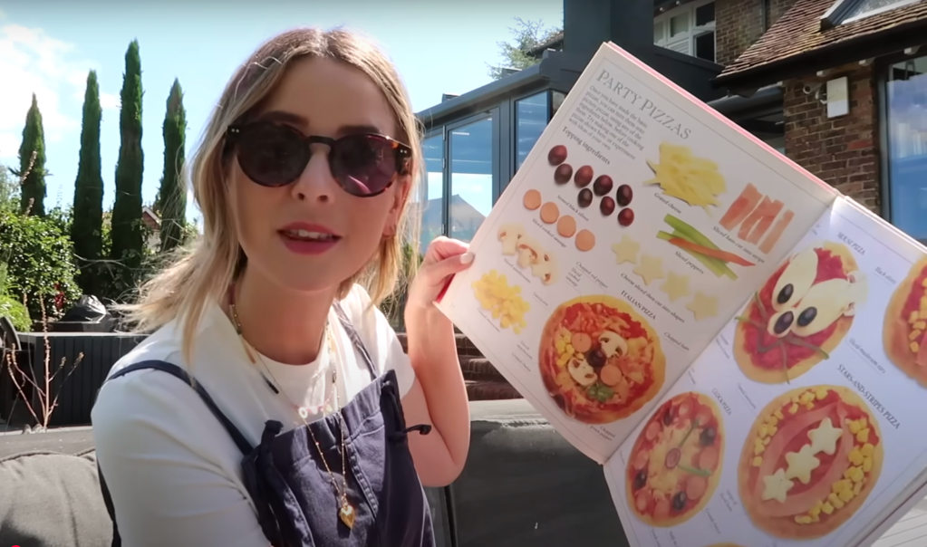 Zoe Sugg holds open a childhood cookbook featuring colorful and playful recipe ideas. 📝